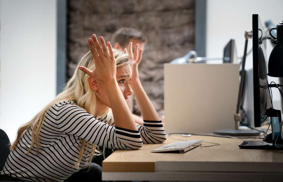 una chica rubia comete un error de linkbuilding delante de su ordenador